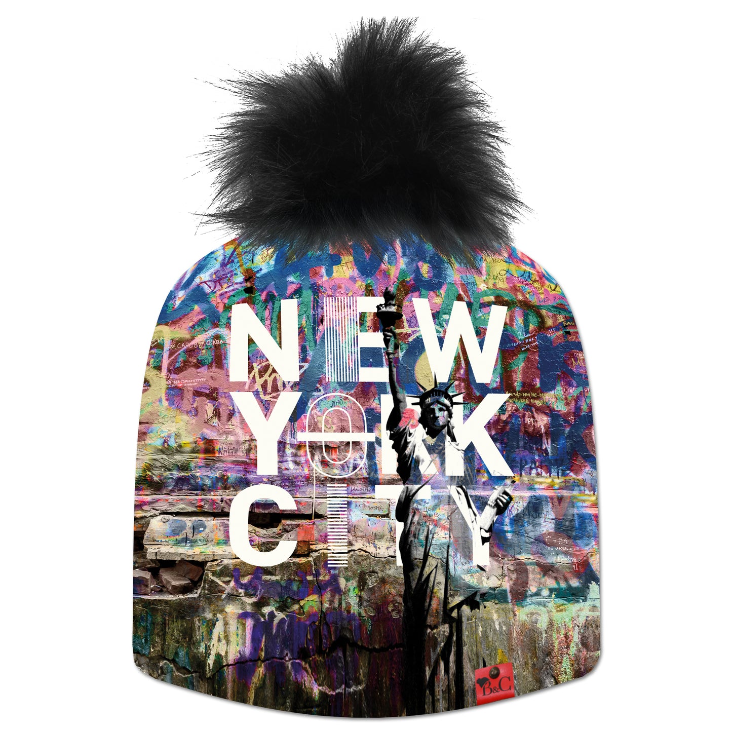 Bonnet Donald pour enfants avec un motif coloré, la statue de la liberté et écrit "New York City". Le bonnet est accompagné de son pompon Oursin en fourrure synthétique et son étiquette en cuir rouge signée Beanie and Clyde.