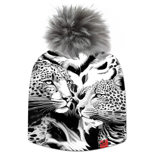 Bonnet Elton pour enfant, motif léopard et guépard en noir et blanc et accompagné de son pompon Gris Raton Laveur en fourrure synthétique et de son étiquette en cuir rouge signée Beanie and Clyde.