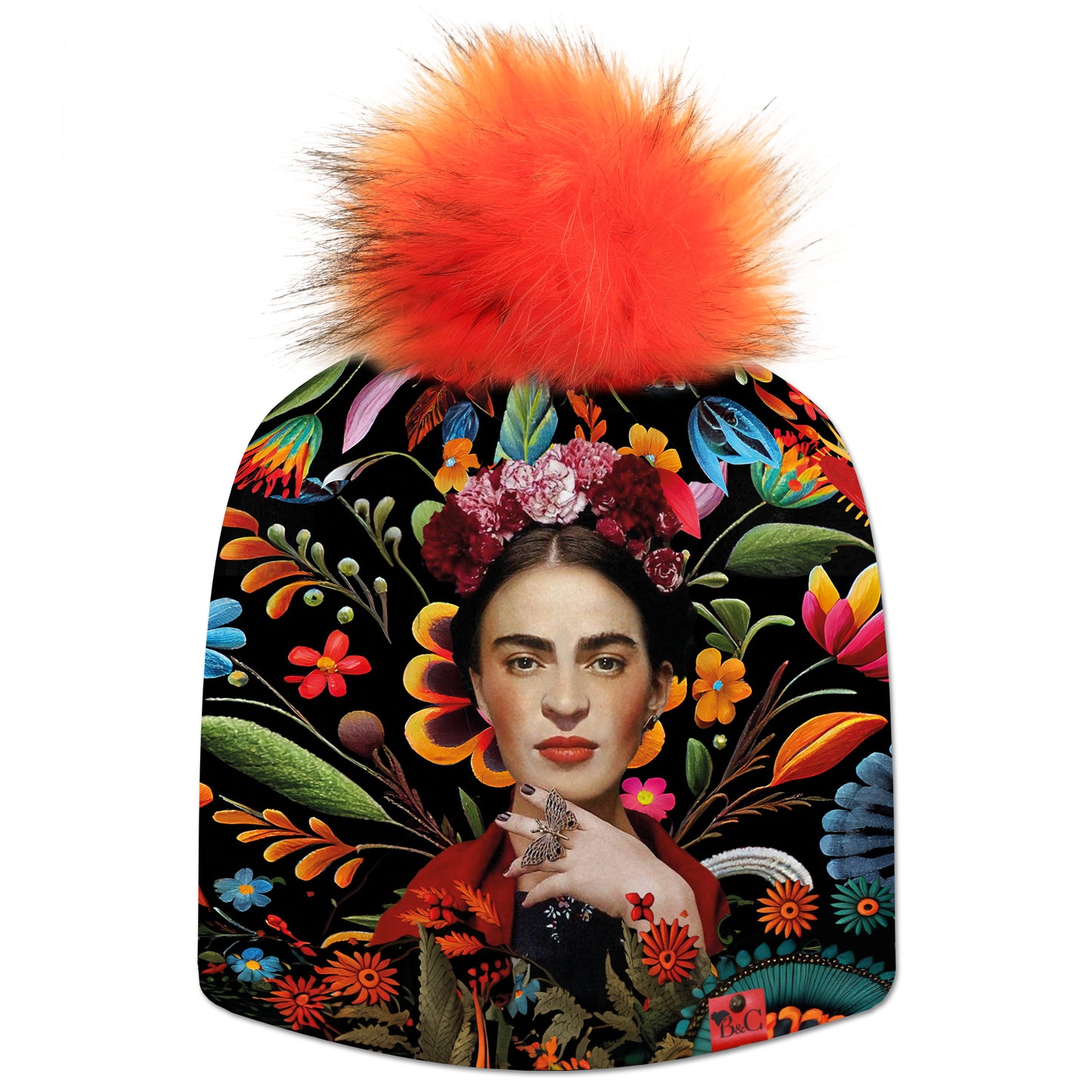 Bonnet Frida pour enfants, avec motif Frida Kahlo sur un fond fleuri très coloré et accompagné de son pompon Renard en fourrure synthétique et son étiquette en cuir rouge signée Beanie and Clyde.