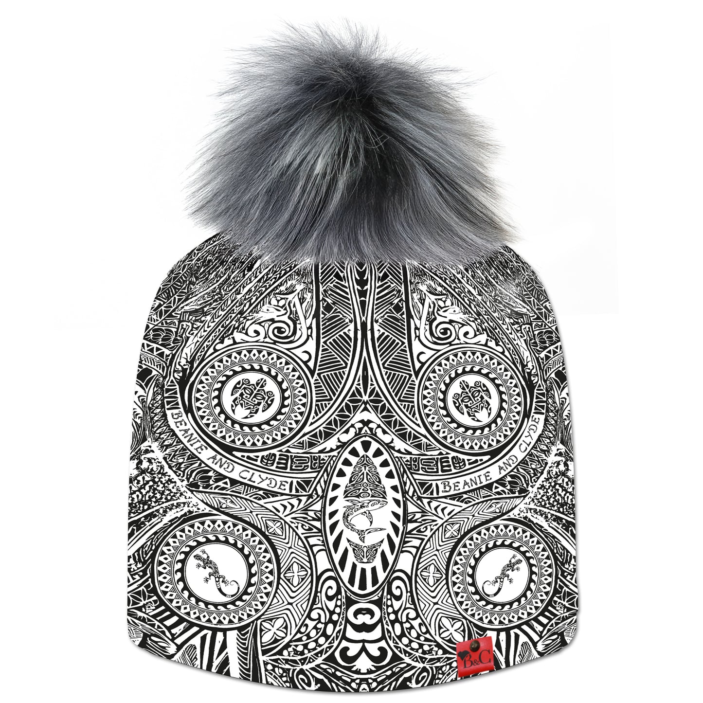 Bonnet Keala pour hommes et femmes, orné de motifs d’inspiration maorie et polynésienne en noir et blanc. Surmonté d’un pompon Poivre & Sel en fourrure synthétique, il est signé de l’emblématique étiquette en cuir rouge Beanie & Clyde.