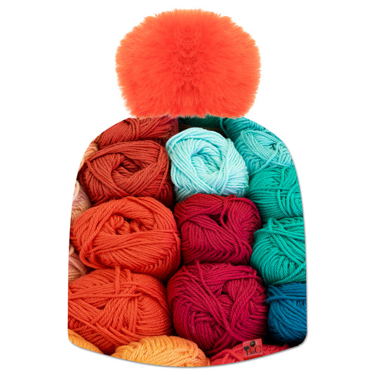 Bonnet Tricotons pour hommes et femmes, avec son imprimé de tricot coloré. Son pompon Orange en fourrure synthétique le sublime ainsi que son étiquette en cuir synthétique rouge signée Beanie and Clyde.