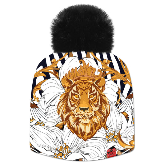 Bonnet Willis pour femmes, avec un motif de feuilles d'or, de signes, de fleurs, avec en point central une tête de lion dorée. Son pompon synthétique noir le sublime ainsi que son étiquette en cuir synthétique rouge signée Beanie and Clyde.