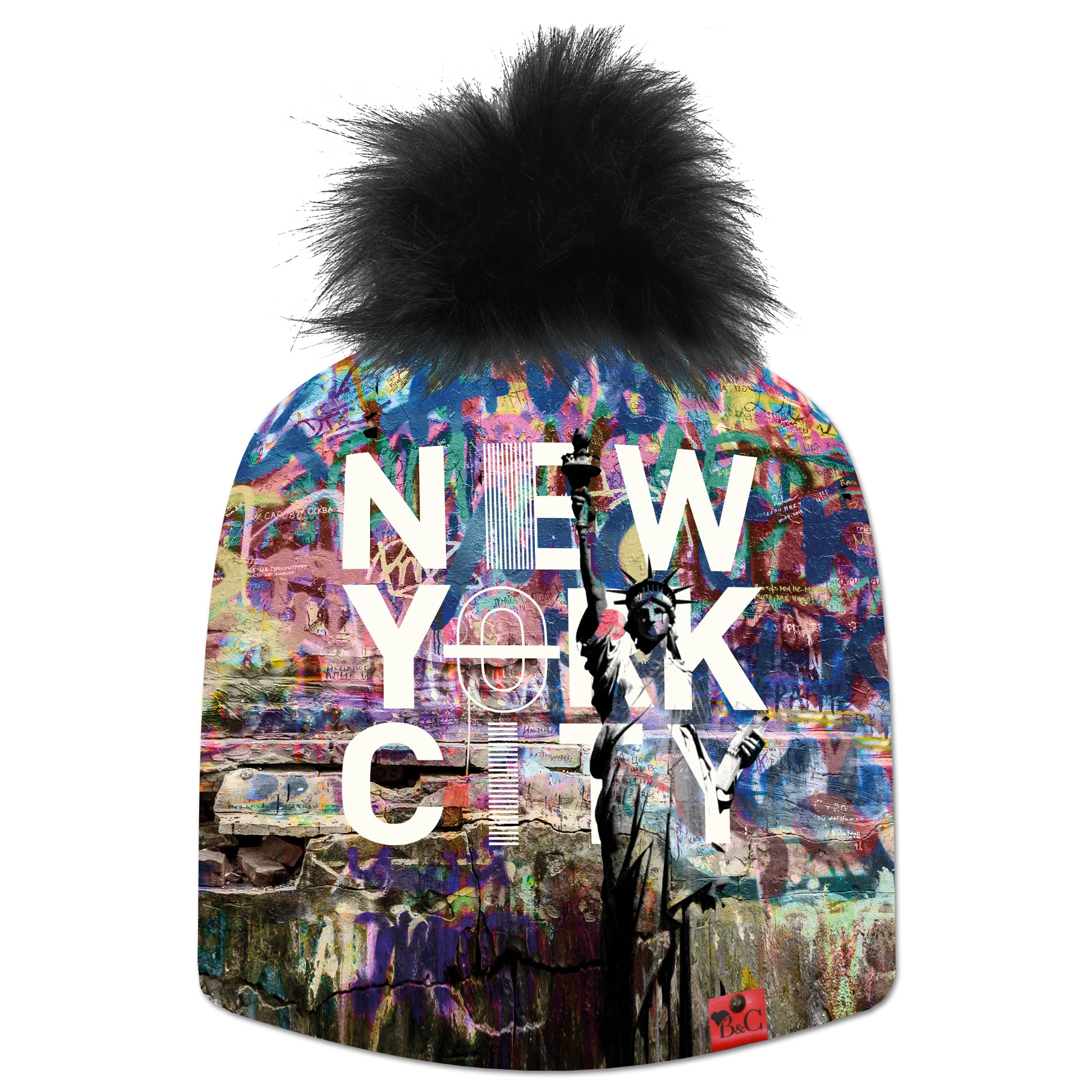 Bonnet Donald pour enfants avec un motif coloré, la statue de la liberté et écrit "New York City". Le bonnet est accompagné de son pompon Oursin en fourrure synthétique et son étiquette en cuir rouge signée Beanie and Clyde.